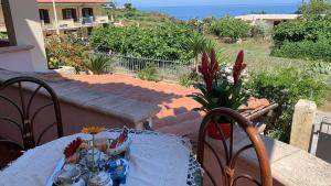 a table and chairs on a patio with a view of the ocean at Villa Annina B&B in Tropea