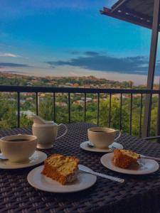 a table with three plates of cake and cups of coffee at Guest House Maradona in Sighnaghi