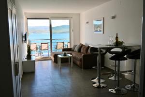a living room with a couch and a table at Apartment First Row in Komarna