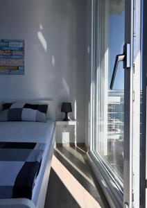 a bedroom with a bed and a large window at Apartment First Row in Komarna