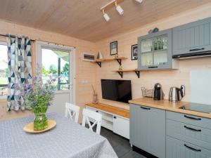 a kitchen with a table with a vase of flowers on it at Szum Fal in Rusinowo