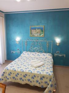 a blue bedroom with a bed with two towels on it at Villa Annina B&B in Tropea