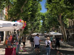 eine Gruppe von Menschen, die mit Sonnenschirmen die Straße hinuntergehen in der Unterkunft Apartamentos del Tenor in Denia