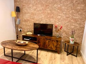 uma sala de estar com televisão num centro de entretenimento em madeira em Casa Mercedes y Pepe em Aracena