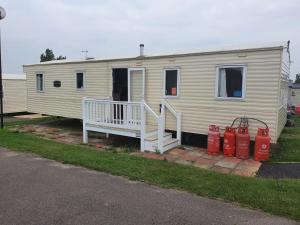 a mobile home with a porch and two fire hydrants at Haven Holiday Home Caister on Sea in Ormesby Saint Margaret