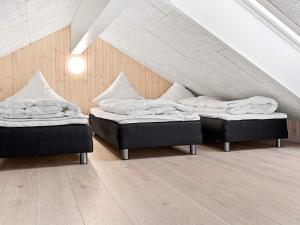 two beds sitting in a room with an attic at 24 person holiday home in Hasselberg in Kappeln +17 photos