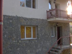 Casa de piedra con escalera y balcón en Vila Iulia, en Sinaia