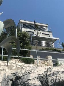 a building on top of a rock in front of a building at Apartment First Row in Komarna