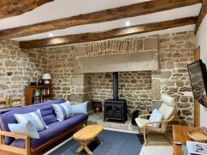 a living room with a blue couch and a stone fireplace at Maison de Bois Royale in Royère-de-Vassivière