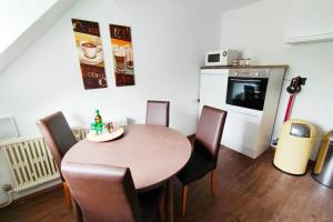 uma sala de jantar com mesa e cadeiras e uma cozinha em Gemütliches Apartment Nähe DU Zentrum/Uni/Hbf/A40 em Duisburg