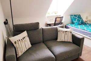 uma sala de estar com um sofá e uma cama em Gemütliches Apartment Nähe DU Zentrum/Uni/Hbf/A40 em Duisburg