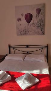 una camera da letto con un letto con coperta rossa e palloncini di Bay's a Spetses