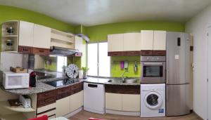 uma cozinha com armários brancos e paredes verdes em CARMELA em Santiago de Compostela