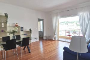 a living room with a table and chairs and a large window at LA PLAGE - Hyper centre - vue port & mer - Climatisation in Cassis