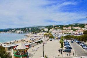 a view of a city with a beach and cars at LA PLAGE - Hyper centre - vue port & mer - Climatisation in Cassis