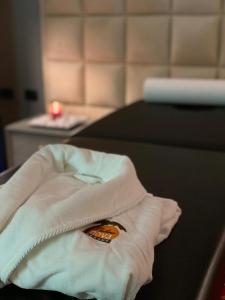 a white towel with a butterfly on it on a bed at PalmaNova Resort in Tirana