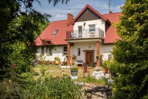 a large white house with a red roof at Sielski wypoczynek blisko Kołobrzegu in Dębogard
