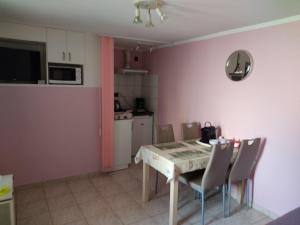 a kitchen and dining room with a table and chairs at Arnika Vendégház in Hajdúszoboszló