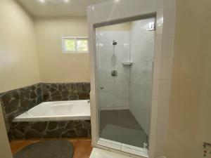 a bathroom with a shower and a bath tub at Coffee Estate Inn in Boquete