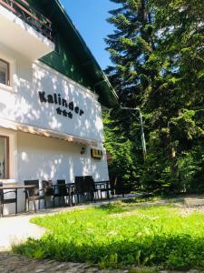 a building with tables and chairs outside of it at Pensiunea Kalinder in Buşteni