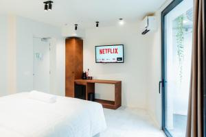 a bedroom with a bed and a desk and a tv at The Librarian by Domani Hotels in Ghent