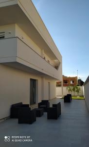 a building with couches and chairs on a patio at Aurea Rooms in Porto Cesareo +29 photos