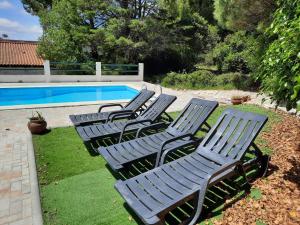 4 chaises longues installées à côté de la piscine dans l'établissement Montejunto Villas - Casa do Plátano, à Cadaval