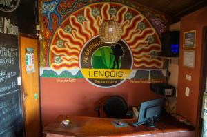 a restaurant with a desk with a computer on a wall at Chapada Backpackers Hostel Agência in Lençóis