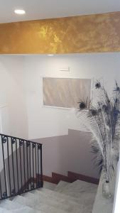 una escalera con una pintura y un jarrón con una planta en Albano Station Rooms, en Pavona
