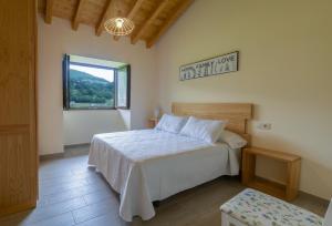 a bedroom with a bed and a window at Complejo Rural El Cerradón in Alceda