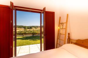 una camera da letto con un letto e una porta scorrevole in vetro di MONTE DA RAPOSINHA Enoturismo, Montargil a Montargil
