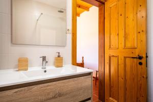 bagno con lavandino bianco e porta in legno di MONTE DA RAPOSINHA Enoturismo, Montargil a Montargil