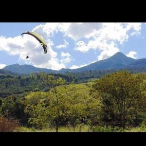 un cerf-volant volant dans le ciel au-dessus d'un champ dans l'établissement Pousada e Restaurante Village Mantovani, à Lavrinhas