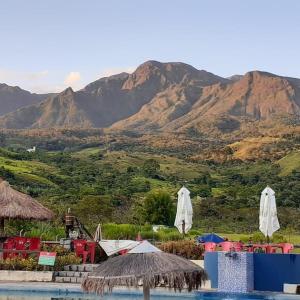 a resort with a pool and mountains in the background at Pousada e Restaurante Village Mantovani in Lavrinhas