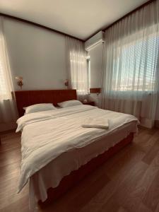 a bedroom with a large bed with white sheets at Hotel Ambient - Struga in Struga
