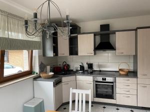 a kitchen with white cabinets and a chandelier at Ferienwohnung Wiek in Wiek auf Rügen 