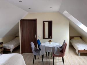 a room with a table and chairs in a attic at Pensjonat Amor in Mielno +35 photos