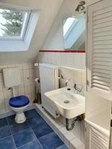 ein Badezimmer mit einem WC, einem Waschbecken und einem Spiegel in der Unterkunft Helle, moderne Altbauwohnung in Zentrumsnähe in Osnabrück