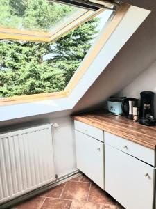 a kitchen with white cabinets and a large window at Helle, moderne Altbauwohnung in Zentrumsnähe in Osnabrück