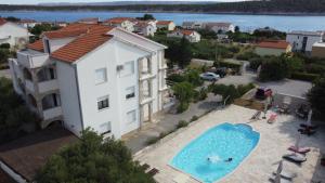 eine Luftansicht auf ein Gebäude und einen Pool in der Unterkunft Apartments Villa Olga in Rab