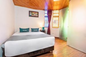 a bedroom with a large white bed in a room at Ayenda Casa Candilejas in Bogotá