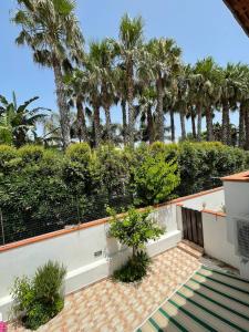 un balcón de una casa con palmeras en La Turrita Apartments en Ischia