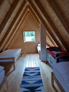 a attic room with two beds and a rug at Brvnara Jahorinka in Jahorina