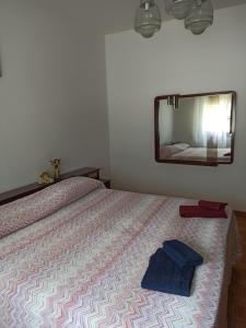 um quarto com uma cama com um espelho na parede em Casa della Nonna em Tramonti di Sopra