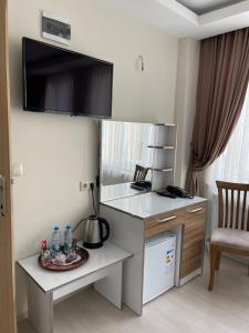 a room with a desk with a microwave and a chair at Bursa Malkoc Hotel in Bursa