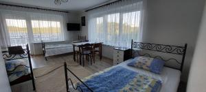 ein Schlafzimmer mit einem Bett, einem Schreibtisch und einem Tisch in der Unterkunft Lemanka in Gowidlino