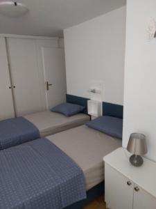 2 Betten in einem blau-weißen Zimmer in der Unterkunft Ellipse apartment in Piran