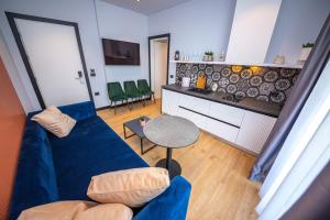 a living room with a blue couch and a table at Apart-Hotel Lili2 in Sarandë