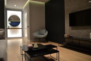 a living room with a couch and a table and a tv at ArtNest Luxury Hotel & Suites in Sarandë