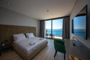 a bedroom with a bed with a view of the ocean at Apart-Hotel Lili2 in Sarandë